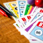 Close-up of colorful bingo game cards fanned out on a wooden table with dauber markers and numbered balls, natural lighting, photorealistic detail showing card texture and vibrant colors