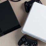 Photorealistic overhead view of PlayStation 4 and PlayStation 3 consoles side by side on a gaming setup with controllers, showing the hardware generation gap and console design evolution