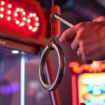 Professional arcade carnival hook and ring game setup with classic wooden frame, hanging ring on string, and polished steel hook, vibrant neon lighting, close-up of player's focused hands in mid-swing motion, photorealistic arcade environment