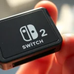 Close-up of a Nintendo Switch 2 game cartridge with metallic contacts, held in sunlight showing the polished surface, photorealistic detail of the card's physical design and dimensions