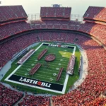 Overhead stadium view during NFL game with packed crowd in red and gold team colors, vibrant energy and excitement, thousands of fans cheering